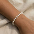 Pearl beaded bracelet on a wrist with a neutral background