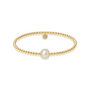 Gold beaded bracelet with a pearl on a white background