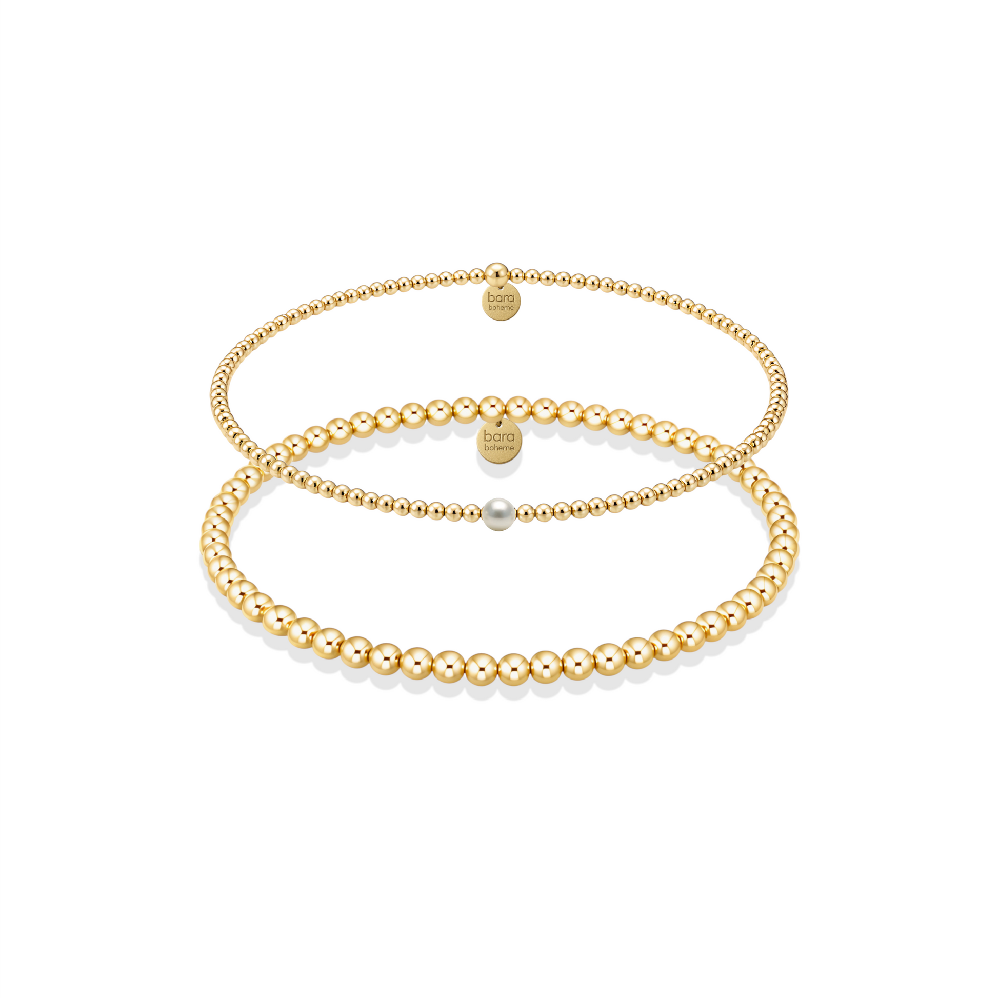 Two gold pearl bracelets on a white background