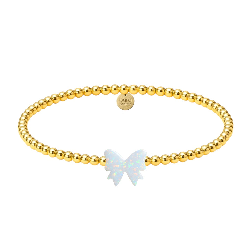 Gold beaded bracelet with a butterfly charm on a white background