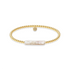 Gold beaded bracelet with a central pearl on a white background