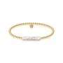 Gold beaded bracelet with a central pearl on a white background