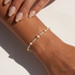 Pearl beaded bracelet on a wrist with a neutral background