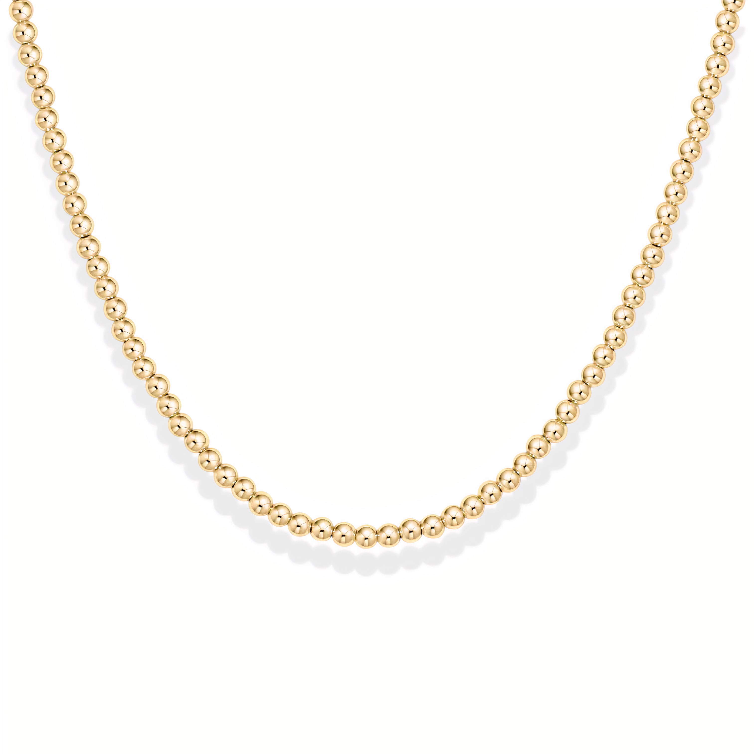 Gold beaded necklace on a white background