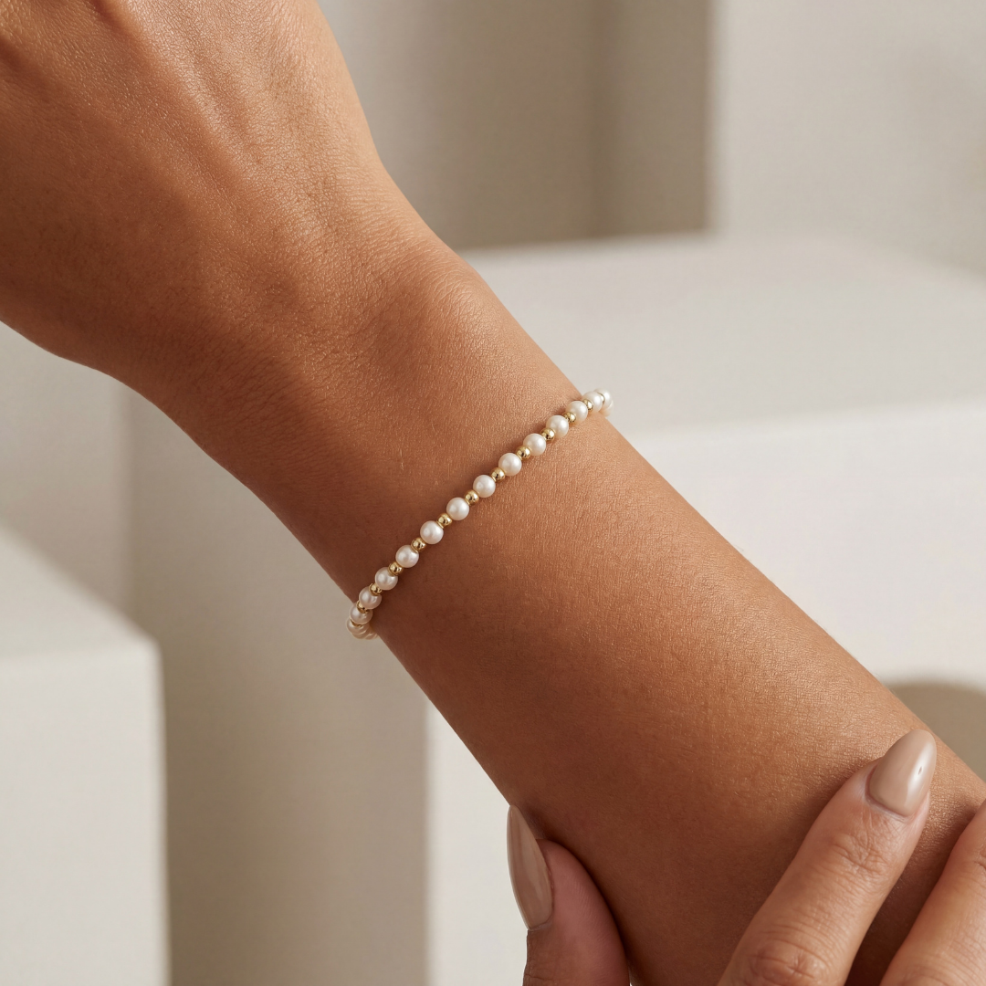Pearl beaded bracelet on a wrist with a neutral background