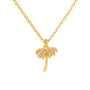 Gold palm tree necklace on a white background