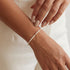 Pearl beaded bracelet on a wrist with a neutral background
