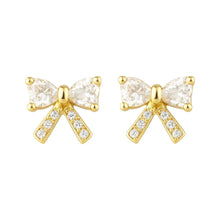 Gold bow-shaped earrings with clear gemstones on a white background