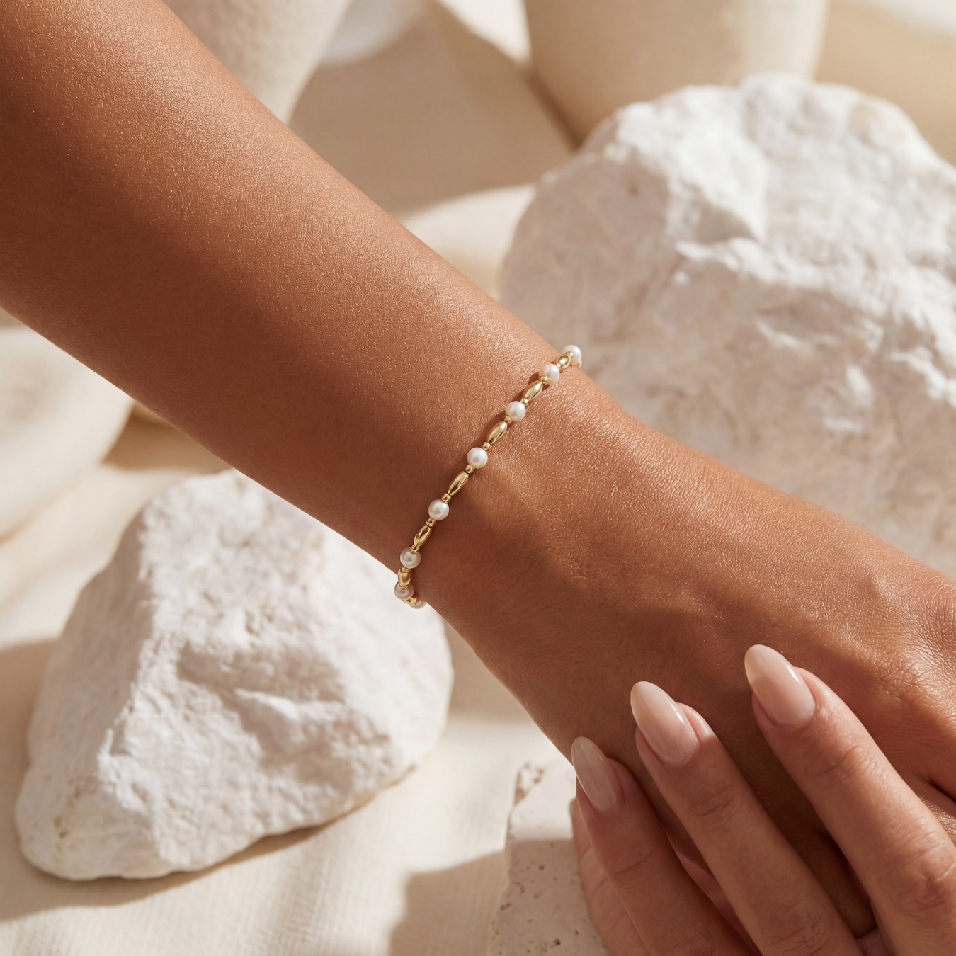 Pearl beaded bracelet on a wrist with a natural stone background