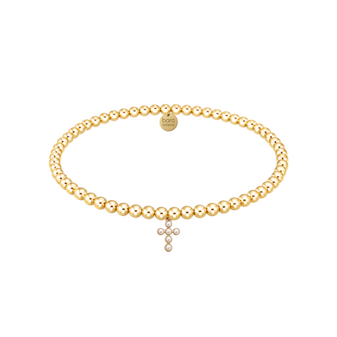 Gold pearl cross charm bracelet on a white background